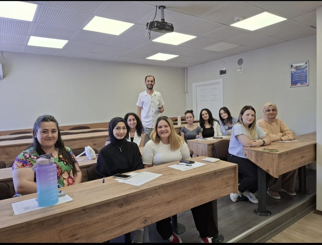 Amfi sınıfta ders öncesi bir araya gelen öğrenci grubu ve öğretmenleri