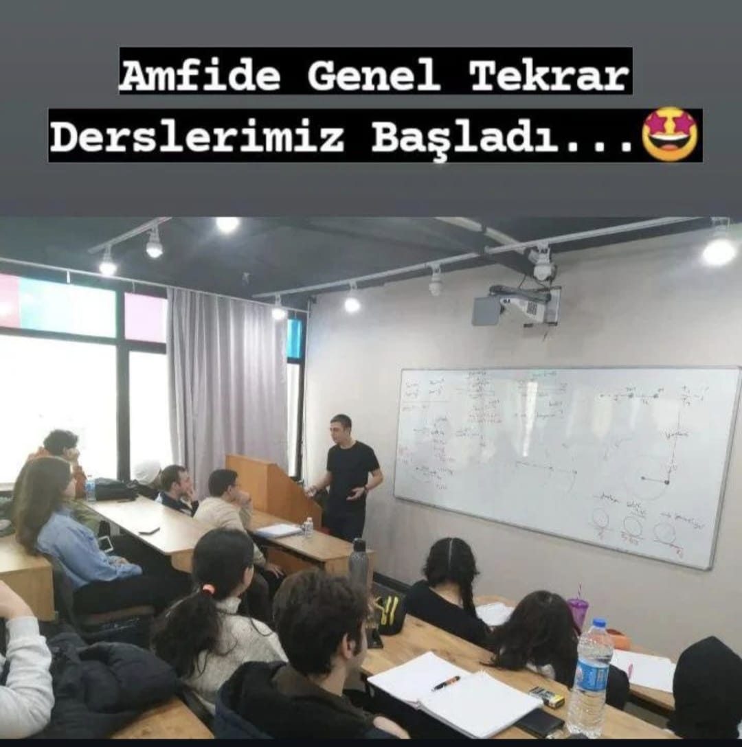 Amfi sınıfta genel tekrar dersini anlatan öğretmen