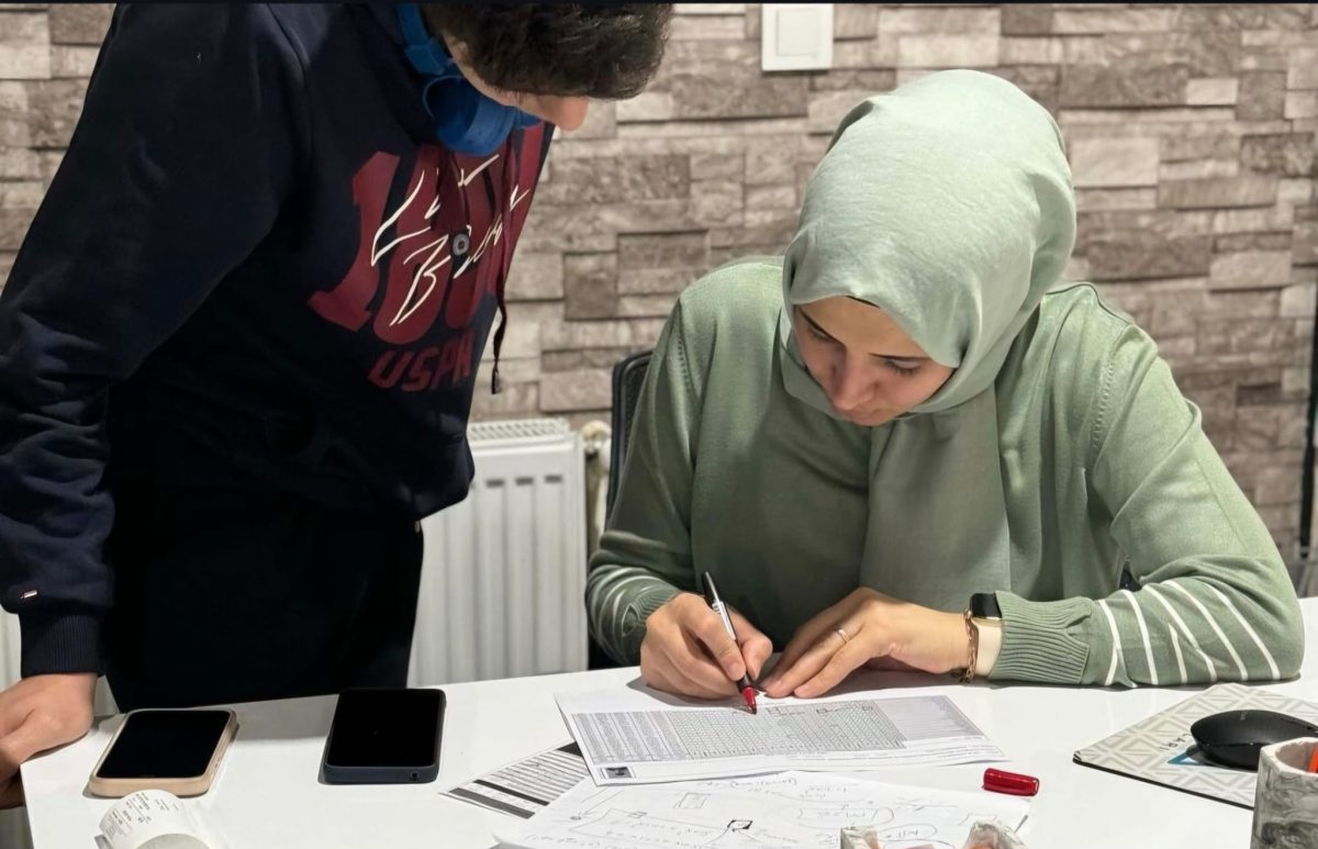 Öğretmenin öğrenciye masa başında soru çözümü